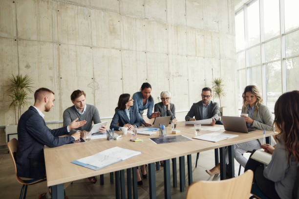 Large group of entrepreneurs working on computers and paperwork during a meeting in the office. Copy space.